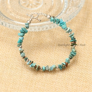 Pode incluir: Um bracelete de lascas de turquesa com detalhes prateados e um fecho de correr. O bracelete é feito de pequenas peças irregulares de turquesa.