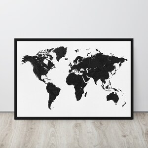 May include: A framed world map art print. The map is a black and white design, with the continents rendered in black against a white background. The artwork is encased in a black frame, suitable for home or office decor.