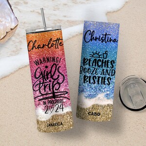 May include: Two personalized stainless steel tumblers with glitter designs. One tumbler is pink and orange with the text "Charlotte Warning! Girl's Trip In Progress 2024 Jamaica". The other tumbler is blue and white with the text "Christina Beaches Booze and Besties Cabo".