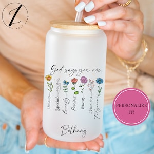 May include: White frosted water bottle with a bamboo lid and a straw. The bottle has a floral design with the text "God says you are" and a list of positive affirmations: Unique, Special, Lovely, Precious, Strong, Chosen, Forgiven. The name Bethany is printed at the bottom of the bottle.