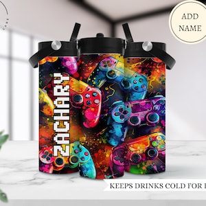 May include: Three colorful water bottles with a gamer theme. The bottles feature a design of colorful video game controllers with a splatter paint effect. The name "ZACHARY" is printed on one of the bottles.