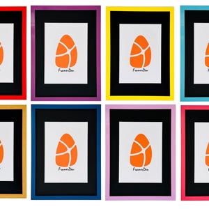 May include: Eight picture frames with vibrant borders in various colours, including red, purple, yellow, blue, gold, and pink. Each frame features a black mount and a white print with an orange abstract design and the text "FramesDen".