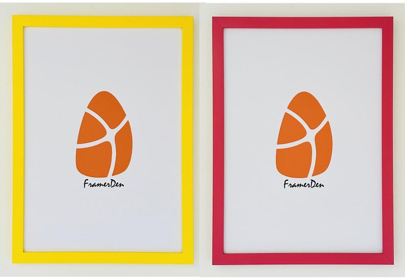May include: Two framed art prints. One frame is yellow, the other is red. Each frame contains a white background with an orange egg-shaped design. The text "FramesDen" is printed in black at the bottom of each print.