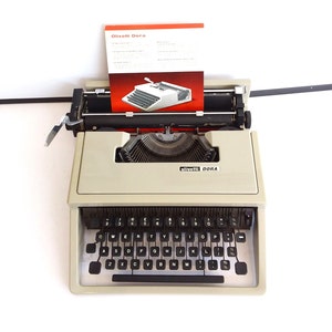 Olivetti Dora  vintage typewriter, 1970&#39;s. cream portable QWERTY typewriter. Blue case.