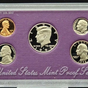 May include: A purple velvet coin case with a clear plastic cover. The case contains a 1992 United States Mint Proof Set. The set includes a penny, nickel, dime, quarter, and half-dollar.