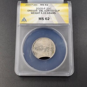 May include: A silver 2005-P 25c Oregon Dbl Curved Clip quarter graded MS 62 by ANACS. The coin features Crater Lake and the text "OREGON 1859".