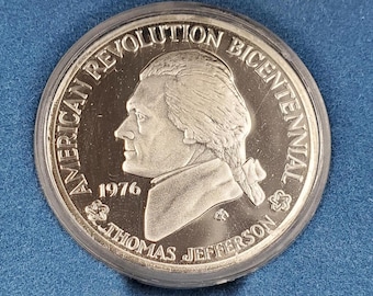 May include: Silver coin commemorating the American Revolution Bicentennial with a profile of Thomas Jefferson and the year 1976.