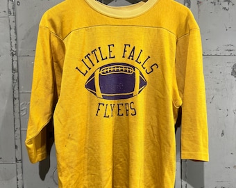Camisa de futebol vintage Champion dos anos 1970, logotipo do futebol Little Falls, tamanho pequeno, barra azul de dois tons, homem correndo