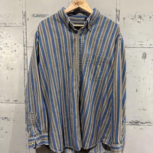 May include: A blue and tan striped long-sleeved button-down shirt.