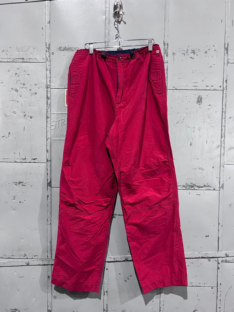 May include: A pair of pink casual trousers with a drawstring waist and side pockets.