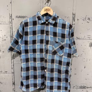 Camisa de flanela com botões, estampa xadrez azul e preta, estilo anos 50, de algodão, com zumbis desgrenhados e desgastados, tamanho médio.