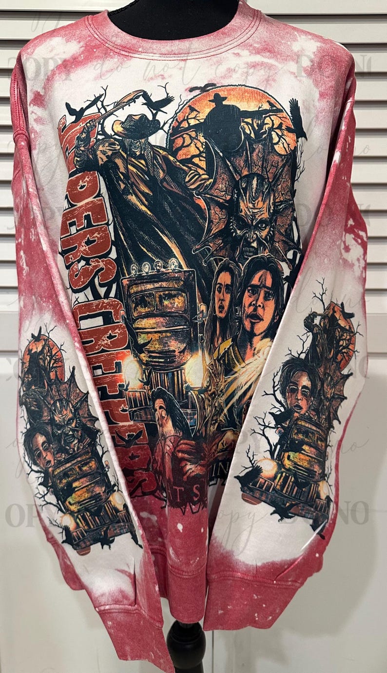 May include: Red and white sweatshirt with a graphic design featuring a horror movie theme. The design includes images of characters, a train, and the words "Riders of the Night". The sleeves have a red and white tie-dye effect.