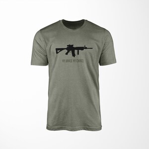 Puede incluir: Una camiseta verde con una silueta negra de un rifle y el texto "MY BRACE MY CHOICE".