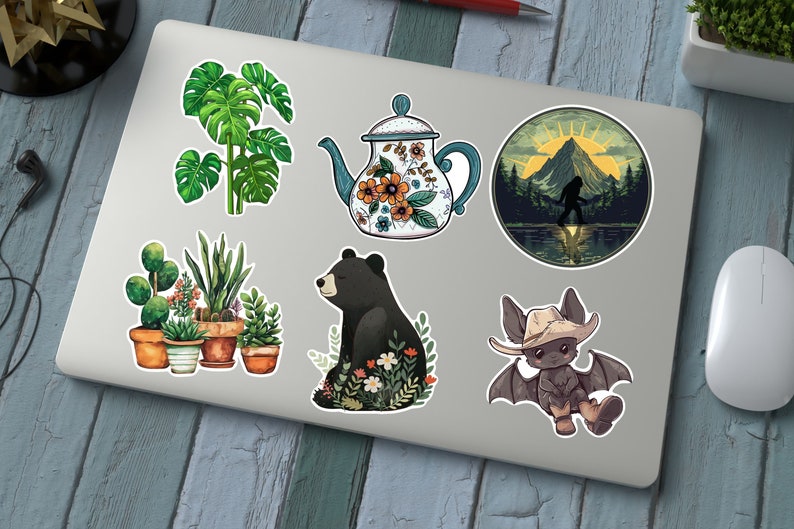 Puede incluir: Un conjunto de seis pegatinas con varios dise&ntilde;os, que incluyen una tetera con patrones florales, un oso negro sentado en un campo de flores, un murci&eacute;lago con un sombrero de vaquero, un grupo de plantas en macetas y una silueta de Bigfoot en una escena de bosque.