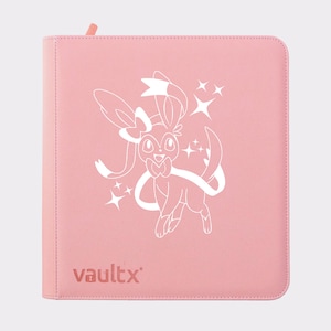 Puede incluir: Un archivador de tarjetas rosa con una ilustración blanca de un personaje de dibujos animados con un lazo y una cinta. La palabra "vaultx" está impresa en la esquina inferior izquierda. El archivador tiene cremallera y tirador rosa.