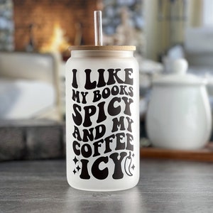 May include: White frosted glass tumbler with a bamboo lid and a straw. The tumbler has black text that reads "I like my books spicy and my coffee icy".