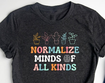 May include: A dark grey t-shirt with a graphic design of potted plants and the text "Normalize Minds of All Kinds".