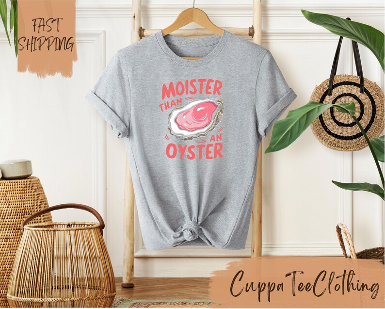 a t - shirt hanging on a wall next to a plant