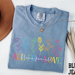 a blue t - shirt with a flower design on it