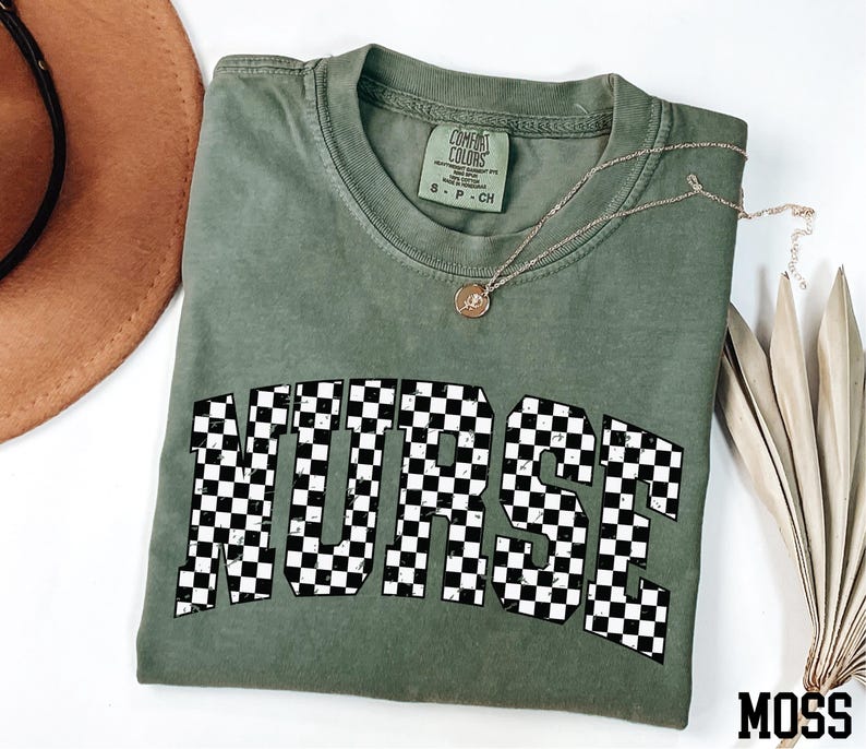 a green t-shirt with the word "NURSE" printed on it, along with a brown hat and some dried leaves.