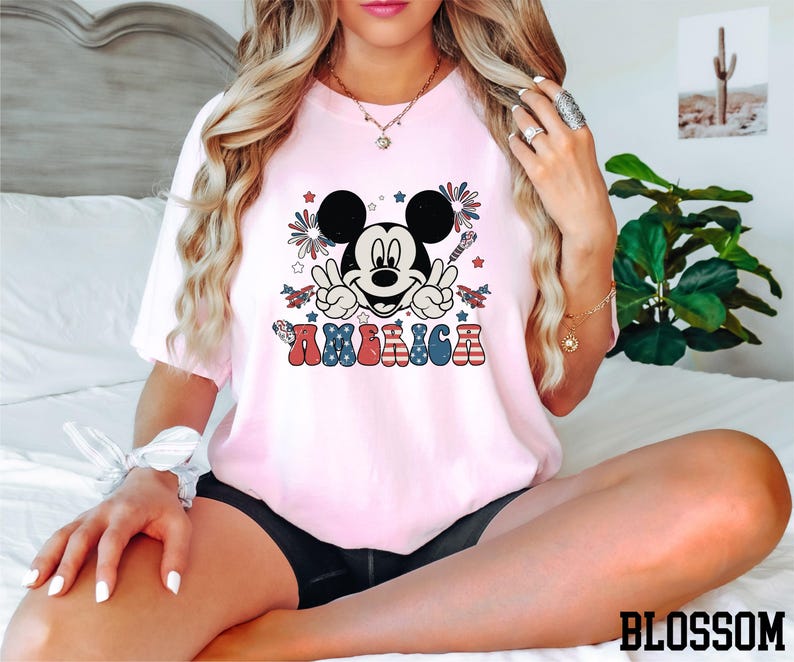 a woman sitting on a bed wearing a minnie mouse shirt