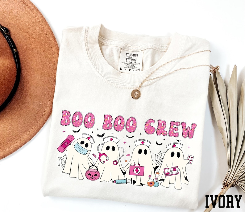 A white t-shirt with a graphic design featuring a group of ghost characters, including a nurse, on a white background.