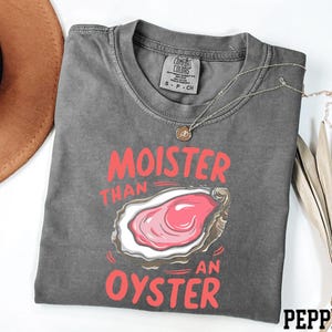 May include: Gray t-shirt with a graphic of an oyster and the text "Moister than an oyster" in red.