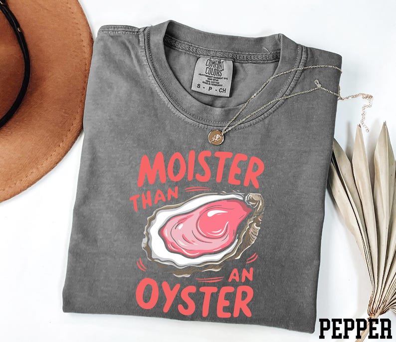 May include: Gray t-shirt with a graphic of an oyster and the text "Moister than an oyster" in red.