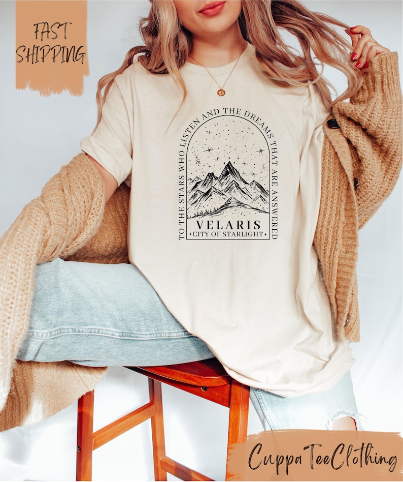 a woman sitting on a stool wearing a t - shirt