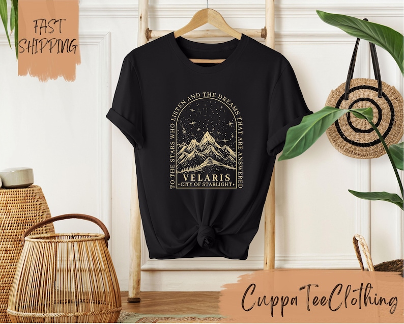 a black t - shirt with a picture of a mountain and stars on it