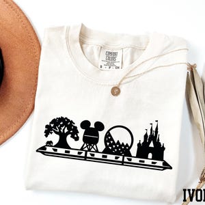 a hat, sunglasses, and t - shirt on a white surface
