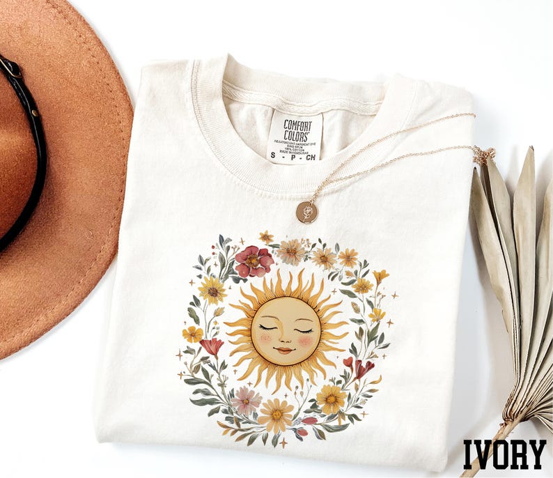 a white t-shirt with a sun design, a brown hat, and a necklace, all arranged on a white background.