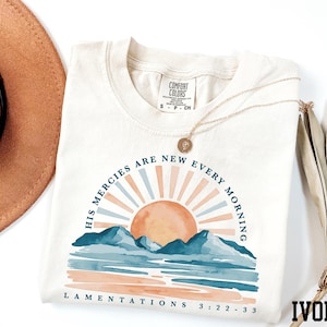 a hat, sunglasses, and t - shirt on a white surface