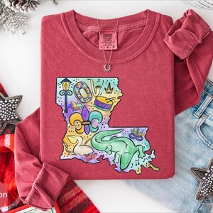 a red t-shirt with a colorful graphic design, a pair of jeans, and some decorative accessories such as a star and a star-shaped charm.