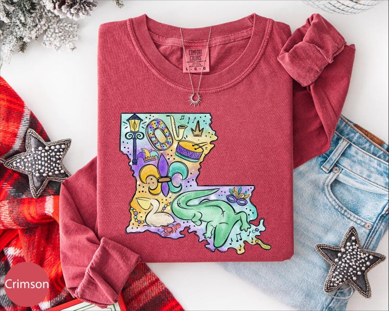 a red t-shirt with a colorful graphic design, a pair of jeans, and some decorative accessories such as a star and a star-shaped charm.