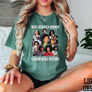 A woman wearing a green t-shirt with a collage of diverse women's portraits and the text "WELL-BEHAVIED WOMEN" printed on it.