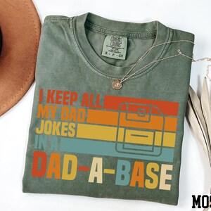 a t - shirt that says i keep all my dad jokes in dad - a