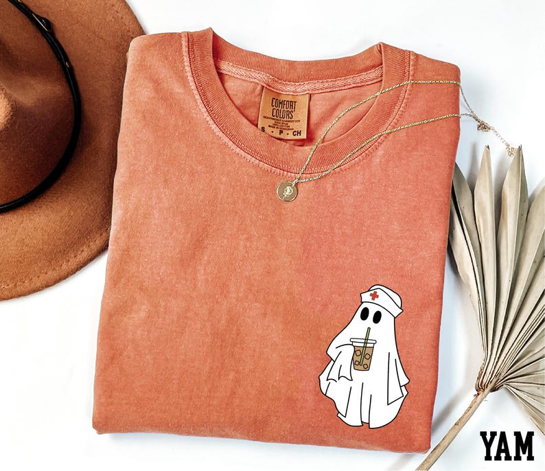 a red t-shirt with a cartoon ghost wearing a nurse's hat and holding a drink, along with a brown hat and a fan.