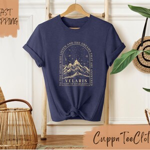 a t - shirt with a picture of a mountain and stars on it
