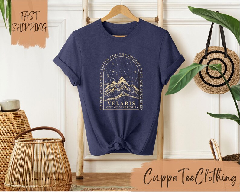 a t - shirt with a picture of a mountain and stars on it