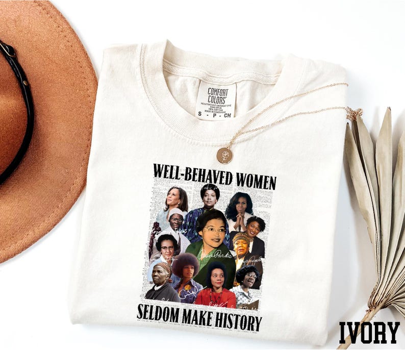 a white t-shirt with a collage of diverse women's faces and the text "WELL-BEHAVED WOMEN SEldom MAKE HISTORY" printed on it.