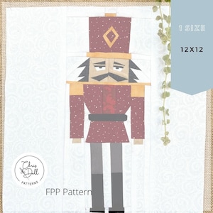 Könnte beinhalten: Ein rot-weißes Papier-Patchwork-Muster eines Nussknackers mit schwarzem Schnurrbart und goldenem Hut. Das Muster ist mit "FPP Pattern" beschriftet und für ein Projekt von 30,5 x 30,5 cm gedacht.