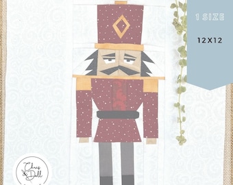 May include: A red and white paper pieced pattern of a nutcracker with a black mustache and a gold hat. The pattern is labeled "FPP Pattern" and is for a 12x12 inch project.