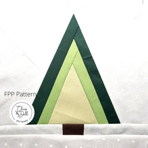 May include: A green, yellow, and brown fabric Christmas tree pattern. The pattern is for a quilt or other fabric project. The pattern is called "Chris & Dell Patterns".