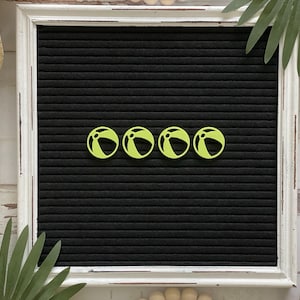 May include: Four yellow beach ball shaped letter board letters on a black letter board.