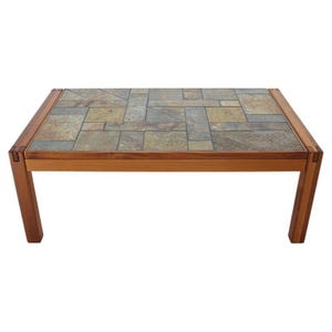 May include: Rectangular coffee table with a mosaic tile top in shades of gray, tan, and brown. The table has a wooden frame and legs. The table is approximately 48 inches long, 24 inches wide, and 16 inches high.