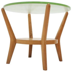May include: A round side table featuring a translucent light green glass top and a light brown wooden base. The structure consists of four angled wooden legs that support both the circular top and a smaller, lower circular wooden shelf.
