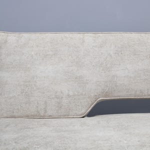 May include: A white fabric sofa with a curved back and a light gray fabric upholstery.