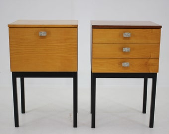 May include: Two wooden nightstands with black metal legs. The nightstand on the left has one drawer, while the nightstand on the right has three drawers. Both nightstands have silver drawer pulls.