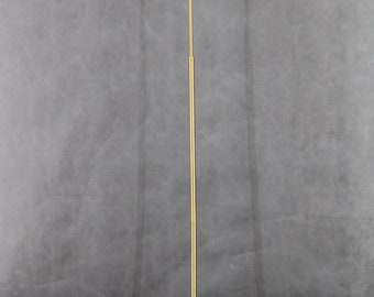 May include: A gold floor lamp with a white shade and a curved arm. The lamp has a simple, modern design.